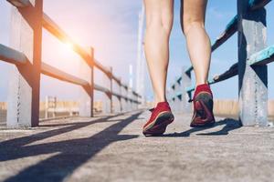 Woman wear running shoe on to walking and running on nature green background.Health exercise. photo