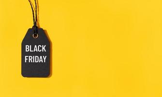 Black friday tag isolated on yellow background with copy space photo