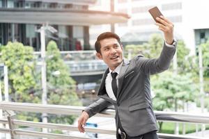 Business man selfie himself by smart phone camera. Business and Technology concept photo