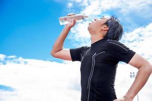 deportista bebiendo agua pura cuando se toma un descanso o descanso, se relaja y se divierte el concepto foto