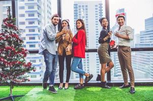 grupo de trabajo en equipo de colega de diversidad empresarial celebaring para la fiesta de año nuevo en el fondo de la oficina urbana moderna. amigos que disfrutan de la fiesta con alcoholivd beben juntos. estilo de vida de la gente de ética múltiple foto