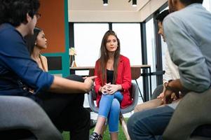 Psychotherapist inquiring about symptoms occurring within mind from patients with mental health problems in hospital. Group psychotherapy for support and helping worried man to change negative mindset photo