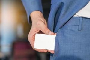 Businessman removing blank white card from his pocket photo