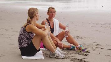 Two women at beach stretching and preparing for run. Shot on RED EPIC for high quality 4K, UHD, Ultra HD resolution. video
