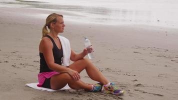 mujer descansando y bebiendo agua después de correr. filmado en rojo épico para una resolución de alta calidad de 4k, uhd, ultra hd. video