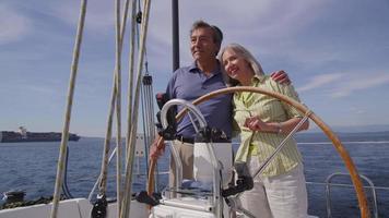 Senior couple behind the wheel of sailboat together. Shot on RED EPIC for high quality 4K, UHD, Ultra HD resolution. video