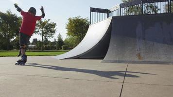 Junge, der im Park Rollerblading fährt, hinfällt video