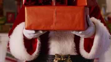 Santa Claus peeks out from behind stack of gifts video