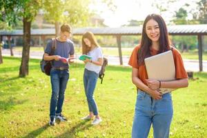 Three Asian young campus people tutoring and preparing for final examination in university. Education and learning concept. Friendship and Relation ship concept. College and Outdoors theme photo