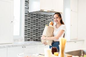 Asian beauty woman holding bag of ingredients for cooking after shopping at supermarket People and lifestyles concept. Food and meal. Happiness of single woman theme. Family and dinner party theme