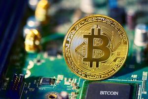 Bitcoin on electronic circuit board. Cryptography and Electronic money concept. Currency trading and Gold mining theme. Business and Technology theme photo