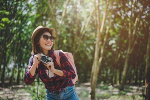 Beauty Asian woman smiling lifestyle portrait of pretty young woman having fun in outdoors summer with digital camera. Traveling of photographer concept. Hipster style and Solo woman theme photo
