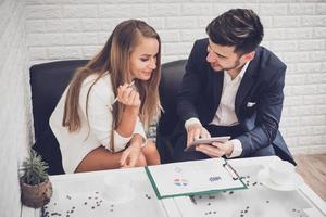 Businessman and business woman analyzing income charts and graphs in coffee shop. Business analysis and strategy concept. Indoors office theme photo