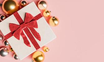 Gift with a large bow and Christmas balls around photo