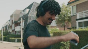 Man with headphone smiles walks and dances on the street video