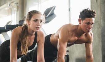 Couple love young fitness man and women workout exercise together. Weight training and cardio program concept. photo