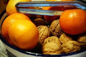 Mandarins and whole walnuts in a bowl with nutcracker photo