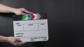 Movie slate or clapperboard hitting. Close up hand holding