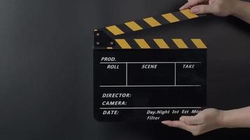 Movie slate or clapperboard hitting. Close up hand holding video