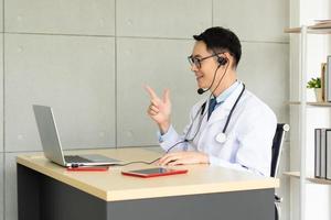 Asian doctor give consult to patient via video call photo