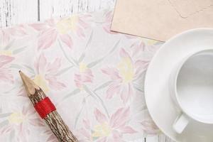 papel floral con lápiz y café