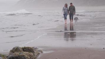 pareja caminando juntos en la playa. filmado en rojo épico para una resolución de alta calidad de 4k, uhd, ultra hd.