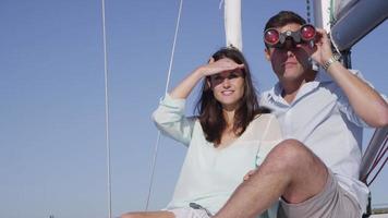junges Paar auf Segelboot zusammen auf der Suche durch ein Fernglas. Aufnahme auf rotem Epos für hochwertige 4k-, UHD- und Ultra-HD-Auflösung. video