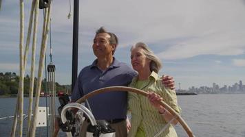 couple de personnes âgées au volant d'un voilier ensemble. tourné sur red epic pour une résolution 4k, uhd, ultra hd de haute qualité. video