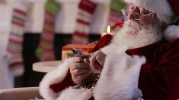 Kerstman met behulp van mobiele telefoon, close-up video