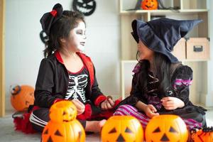 Retrato de un par de niñas en disfraces de halloween y carnaval aislado sobre fondo blanco. foto