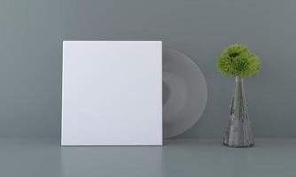 Un paquete de discos de vinilo en blanco con un jarrón sobre una mesa foto