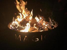 Fire burning in the middle of a fire pit in a campground photo