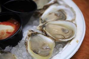 Fresh oysters sitting in their shells on a plate photo