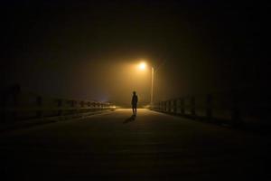 Silhouette of a man under a street light photo