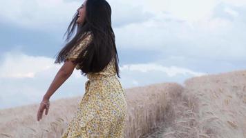 carefree woman enjoying nature while running through a wheat field. Slow motion 4k footage video