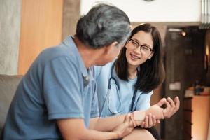 Female therapist doctor exams elderly patient at home. photo