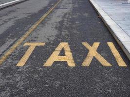 Signo de taxi sobre asfalto