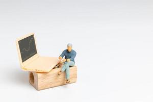 Miniature people, Business people and Labtop featuring stock tickers, photo