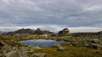 Alpine hut near small mountain lake video