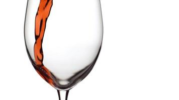slow-motion shot van rode wijn gieten in glas op witte achtergrond. geschoten op phantom flex 4k met 1000 fps