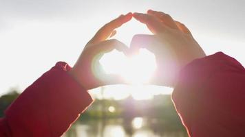 Cerrar la mano de la mujer asiática con la luz del sol durante la puesta de sol. hermosa foto del día, hermoso día y feliz fin de semana. concepto de puesta de sol y río. momento romantico video