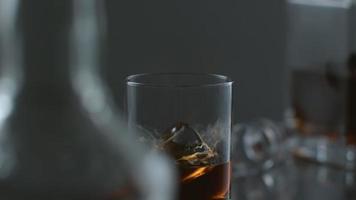 la glace est versée dans un verre de whisky au ralenti. tourné sur phantom flex 4k à 1000 fps video