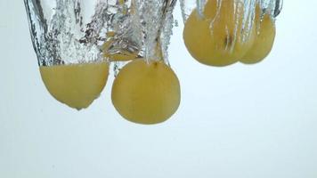 Zitronen spritzen in Zeitlupe ins Wasser. aufgenommen auf Phantom Flex 4k mit 1000 fps video