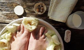 Woman Barefoot In The Water With Milk And White Roses. photo