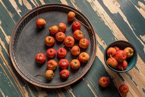 Red hawthorn on a plate or scattered on a wooden table photo