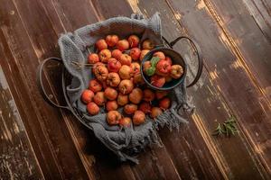 The raw hawthorn on the plate is on the wooden table photo