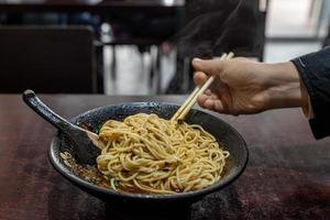 Pick up Chinese food with chopsticks photo