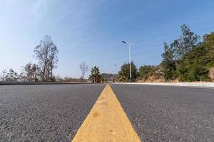 The asphalt road leading to the distance is under the blue sky photo