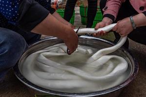 El proceso de producción de bocadillos tradicionales chinos, tiras de arroz, es un manjar hecho a base de arroz. foto