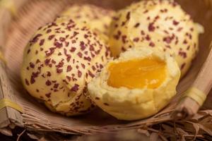 Cut and complete the egg yolk steamed stuffed bun on the wood grain table photo